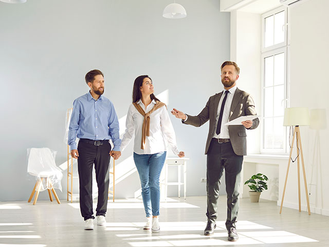 Makler führt Paar durch eine Wohnung