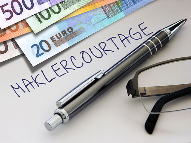 Blatt mit Aufschrift Maklercourtage, daneben liegt ein Kugelschreiber und Geld