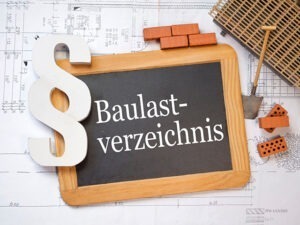Tafel mit Aufschrift Baulastenverzeichnis, daneben Ziegel und Bauunterlagen